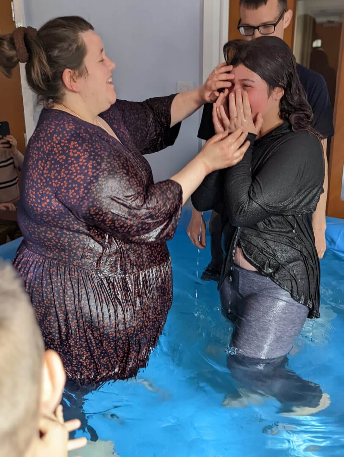 a woman touching another woman's face in water